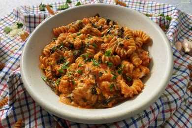Fusilli in tomato sauce with chopped parsley and shredded cheese