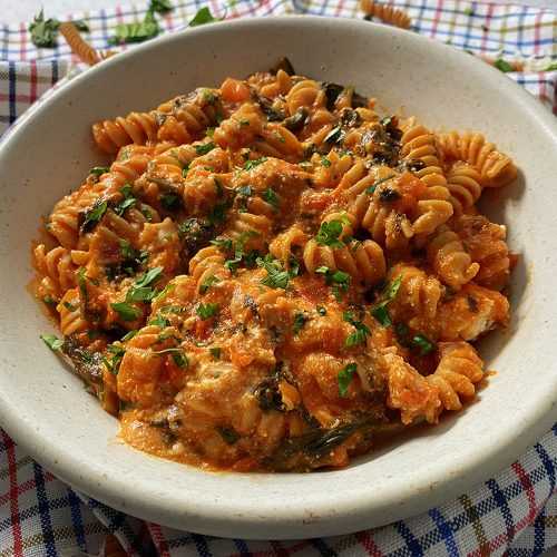 Fusilli in tomato sauce with chopped parsley and shredded cheese