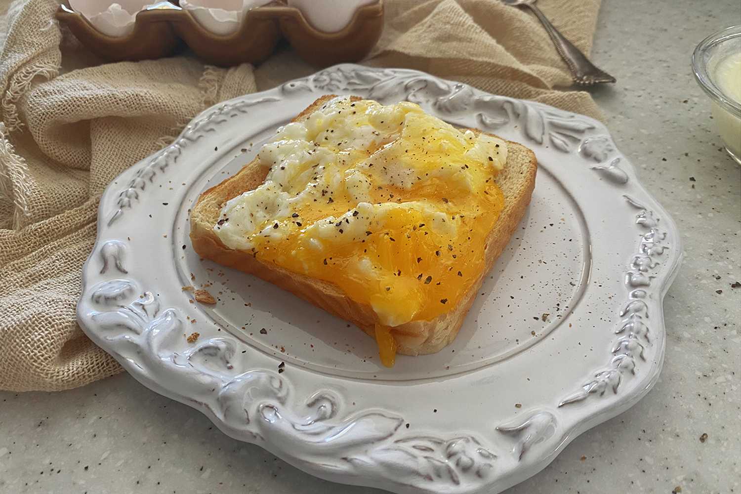 Poached Eggs on a toasted bread on a decorated white plate