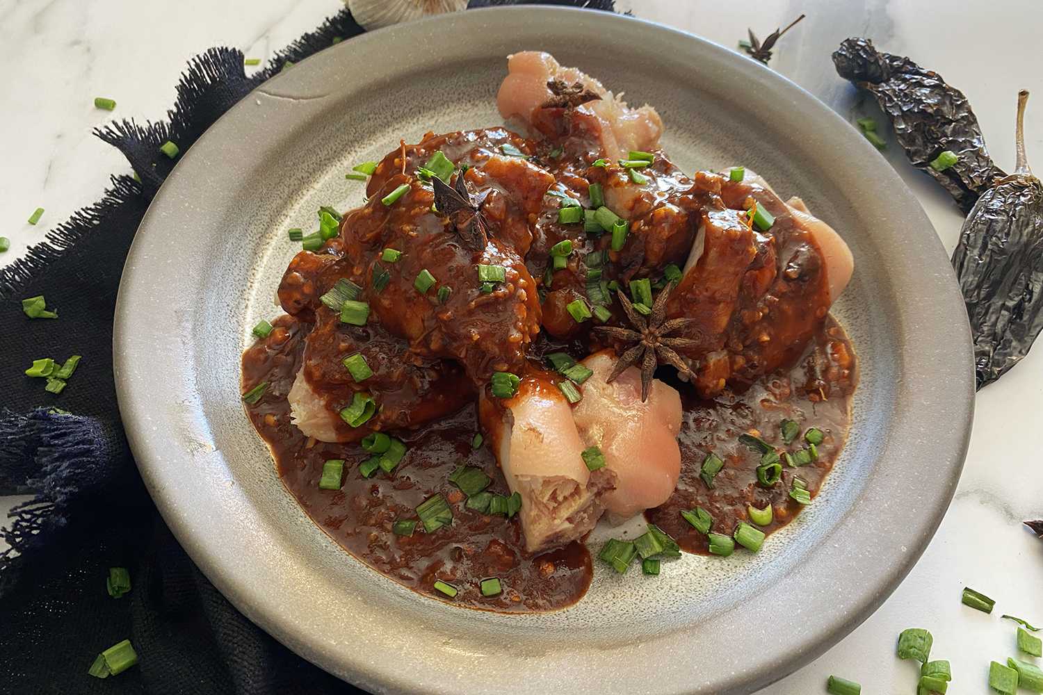 Cooked pork hocks with brown sauce and scallion sliced on top