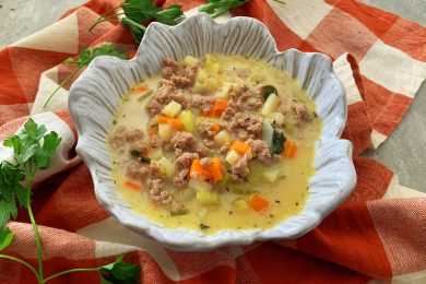 Cheeseburger soup with ground beef, chopped potatoes, carrot and celery