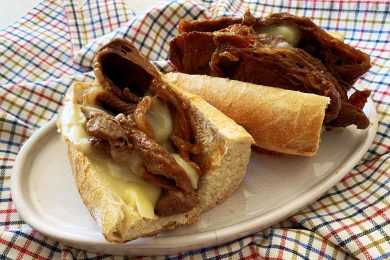 Sub rolls cut into half filled with chuck roast slices and melted cheese top view