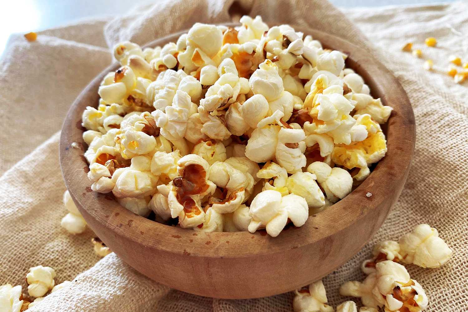 Popcorn in brown bowl with more popcorn on side