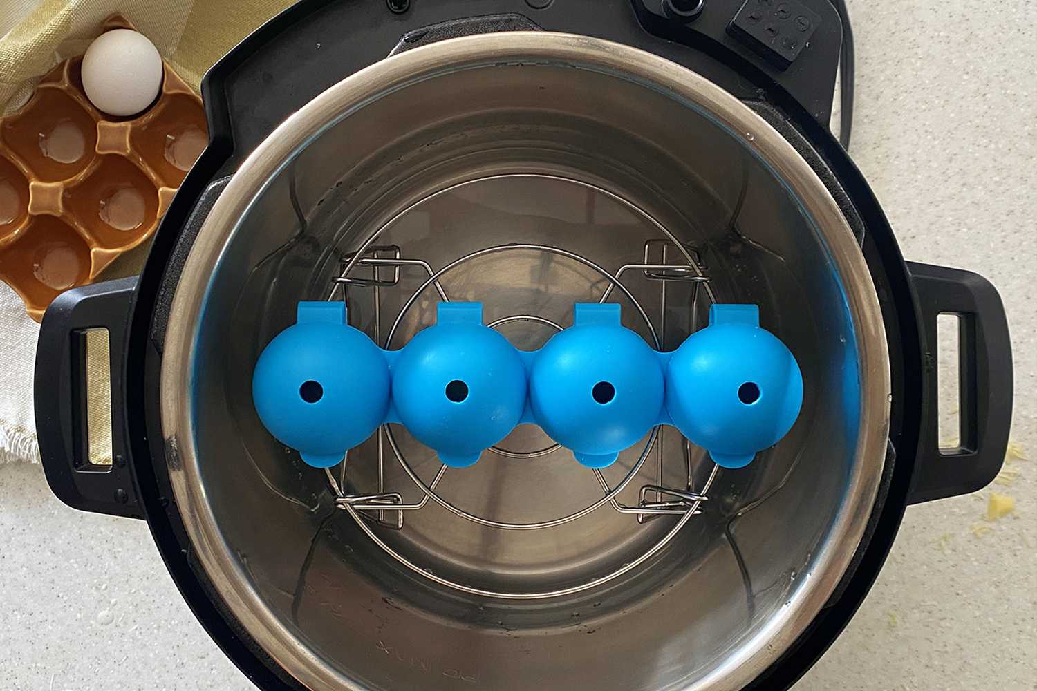 blue egg molds inside a trivet inside instant pot