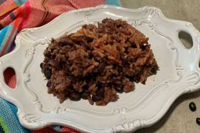 Black beans with rice in tomato sauce in white plate