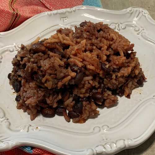 Black beans with rice in tomato sauce in white plate