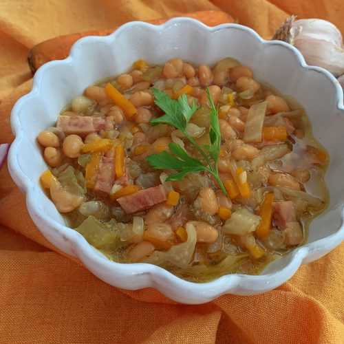 Instant Pot Ham and Bean Soup in a white soup bowl topped with fresh parsley