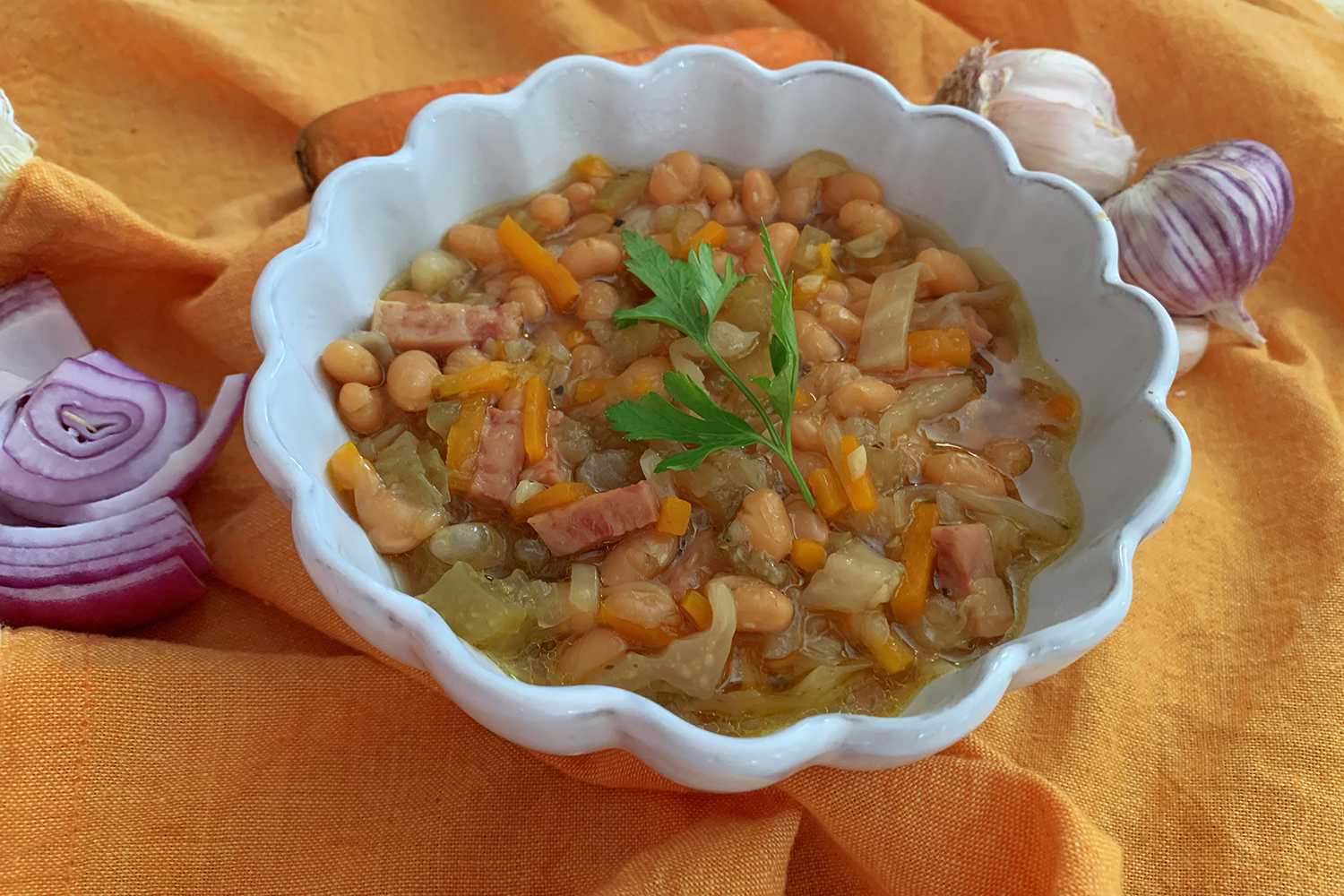 Instant Pot Ham and Bean Soup in a white soup bowl topped with fresh parsley