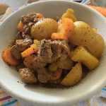Beef cubes with chopped carrot and potato cubes with ground pepper and spices on top