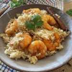 Jasmine rice with shrimp topped with parsley with cinnamon stick on side