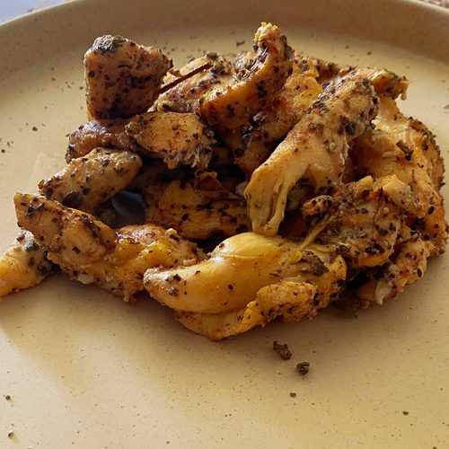 Chicken tenders in white plate topped with black pepper and spices