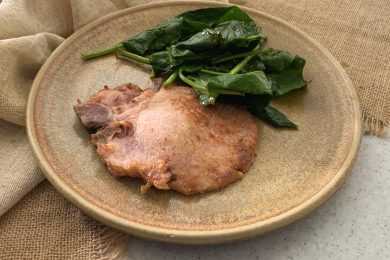Pork Chop with spinach on side on brown plate top view