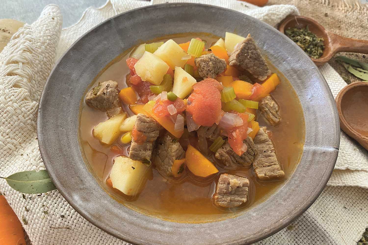 Beed cubes with potato cubes, chopped celery, carrot slices in a brown soup