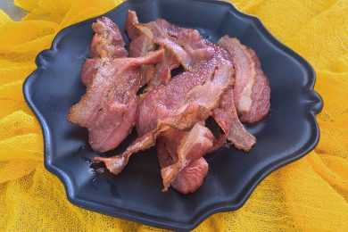 cooked bacon piled on a plate