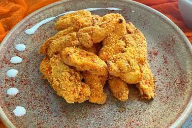 Homemade chicken nuggets coated with bread crumbs and paprika on a grey plate