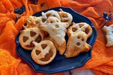 ghost and Halloween pumpkin shaped empanadas filled with pumpkin puree in blue plate
