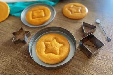 3 Korean Dalgona Candies in a metal trivet with square and star shapes on top