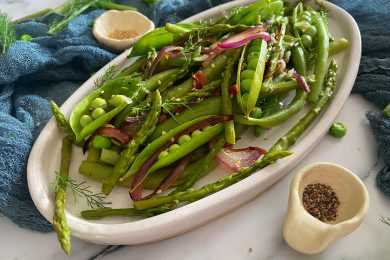 green beans ready to be served with red onion slices in a white plate top view