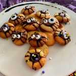 Sugar cookies decorated with chocolate syrup , sprinkles and scary eyes
