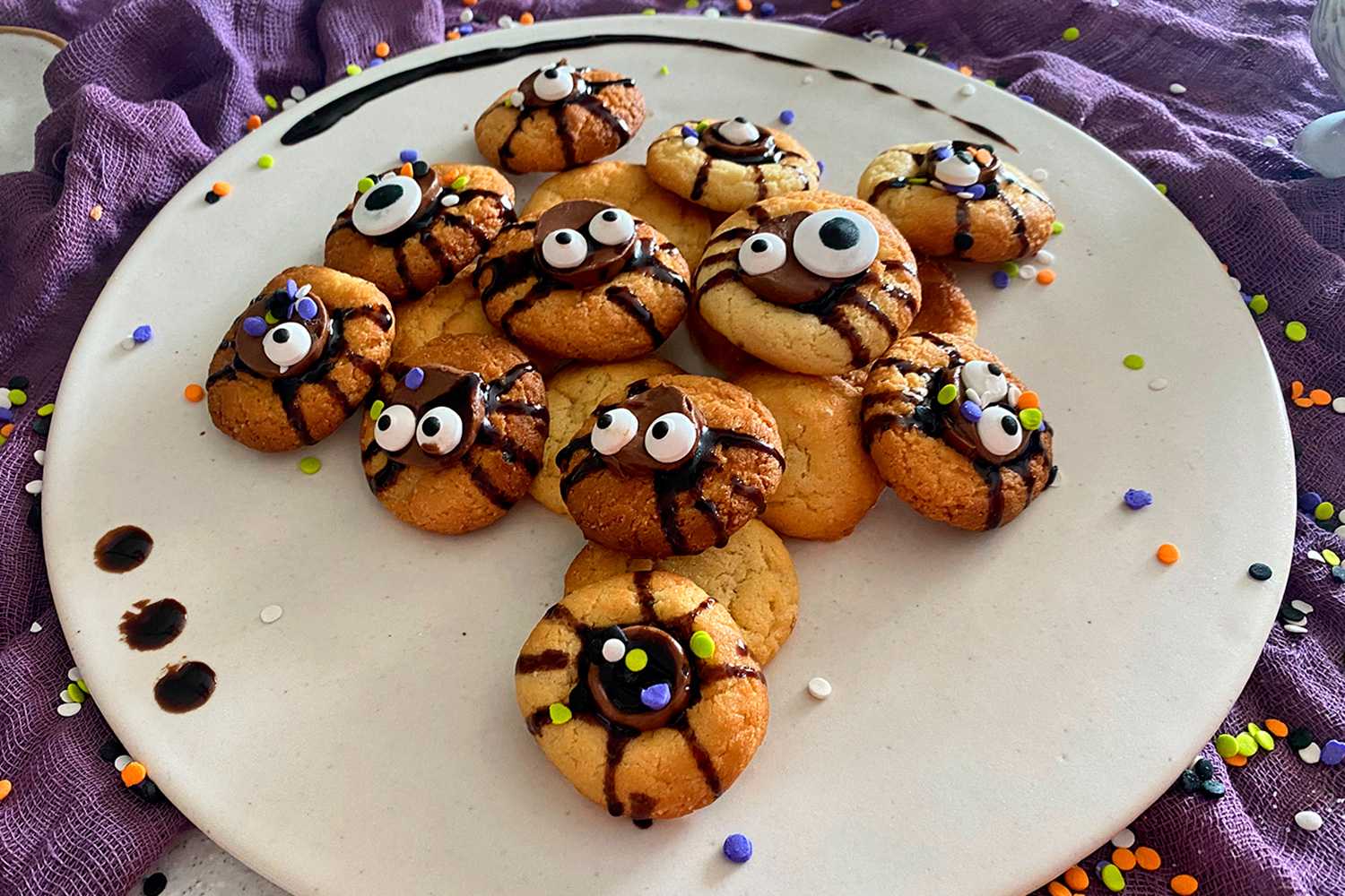 Sugar cookies decorated with chocolate syrup , sprinkles and scary eyes
