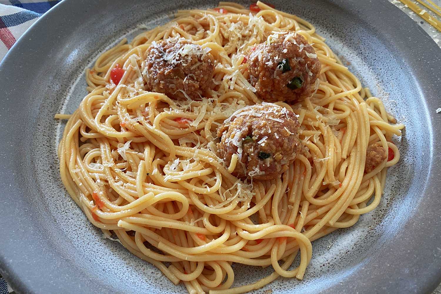 Kuhani špageti s umakom od rajčice preliveni sirom i mesnim okruglicama