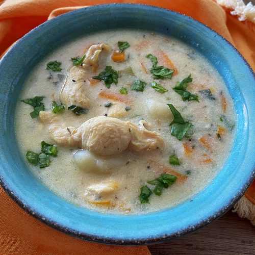 gnocchi soup with chicken served in a blue bowl