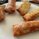 5 Fried crispy Egg Rolls on a white plate close view
