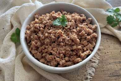 Cooked ground Beef on a gray plate with parsley leaves on top