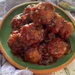 meatballs sitting in a green plate with grape jelly sauce