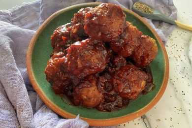 meatballs sitting in a green plate with grape jelly sauce