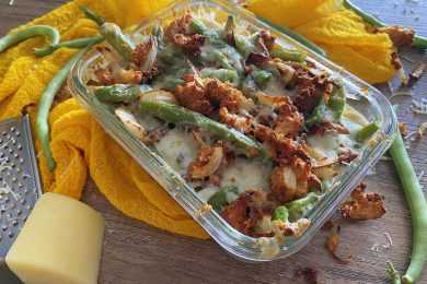 square glass bowl with green bean, onion slices and melted cheese