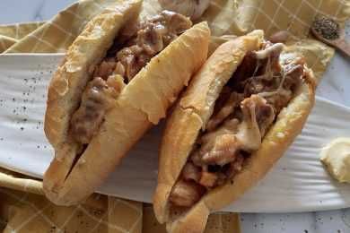 2 baguettes filled with beef steak slices and melted cheese top view