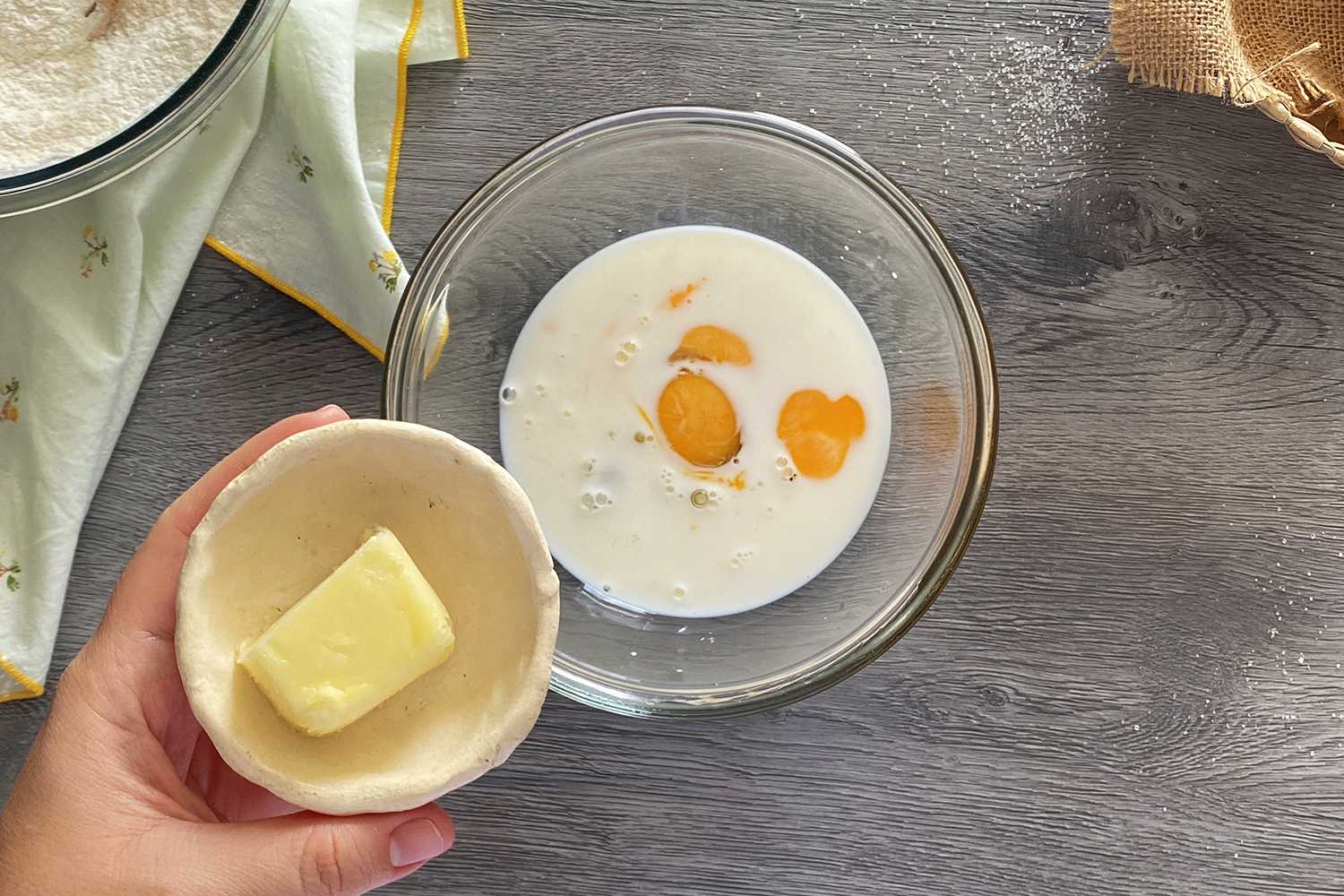Adding butter to a bowl with milk and eggs