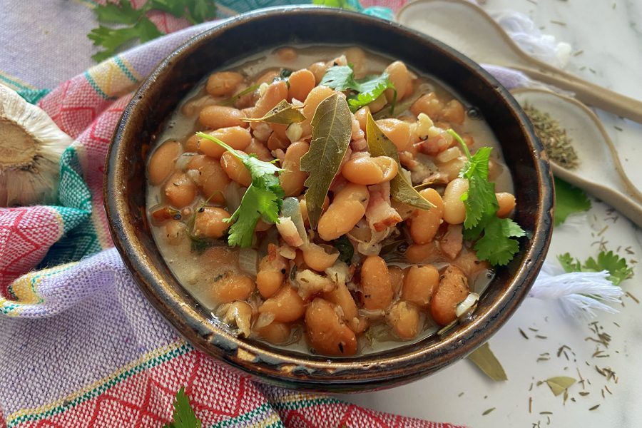 charro beans in a soup top with bay leaves in a brown bowl