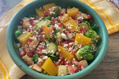blue bowl of quinoa salad with squash and brussel sprouts