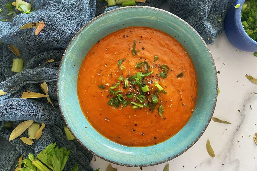 tomato basil soup top with chopped parsley leaves in a bowl top view