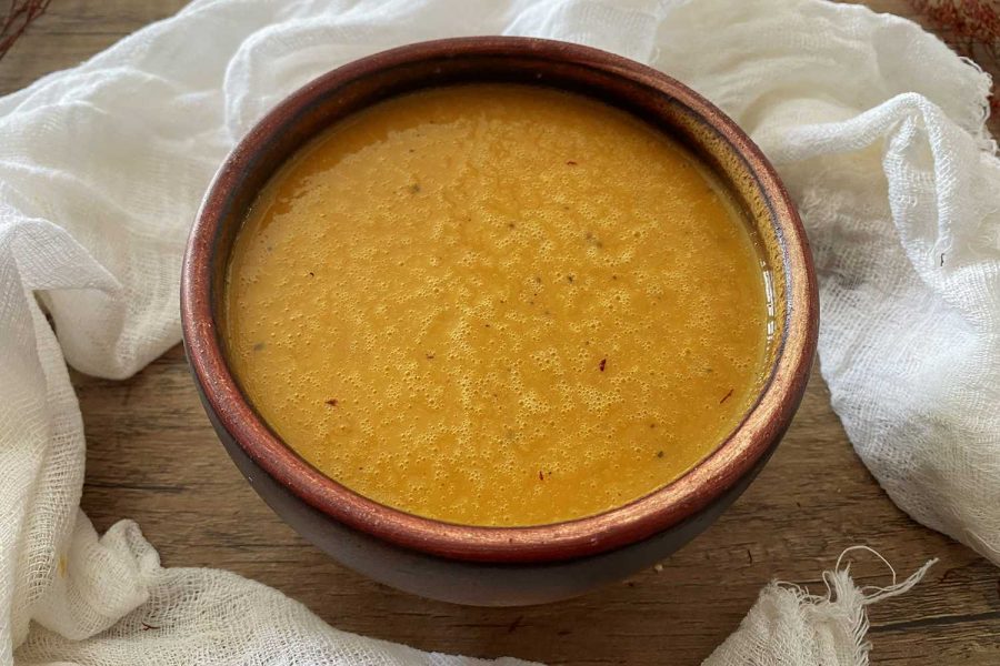Kabocha Squash Soup ready to be served in a brown bowl