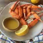 crab legs on a plate with lemon and sauce