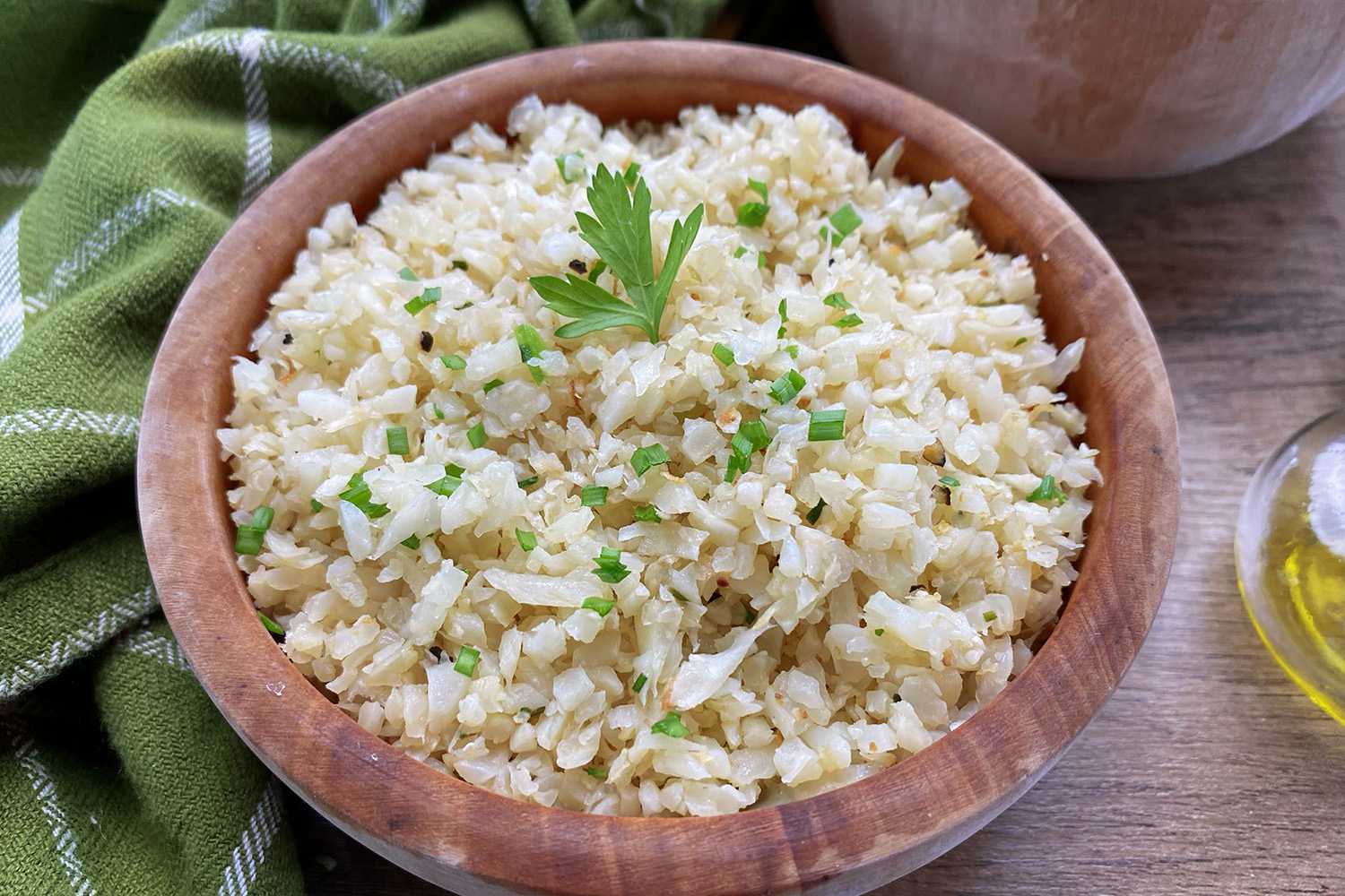 Rice made from cauliflower topped with parsley in brown bowl