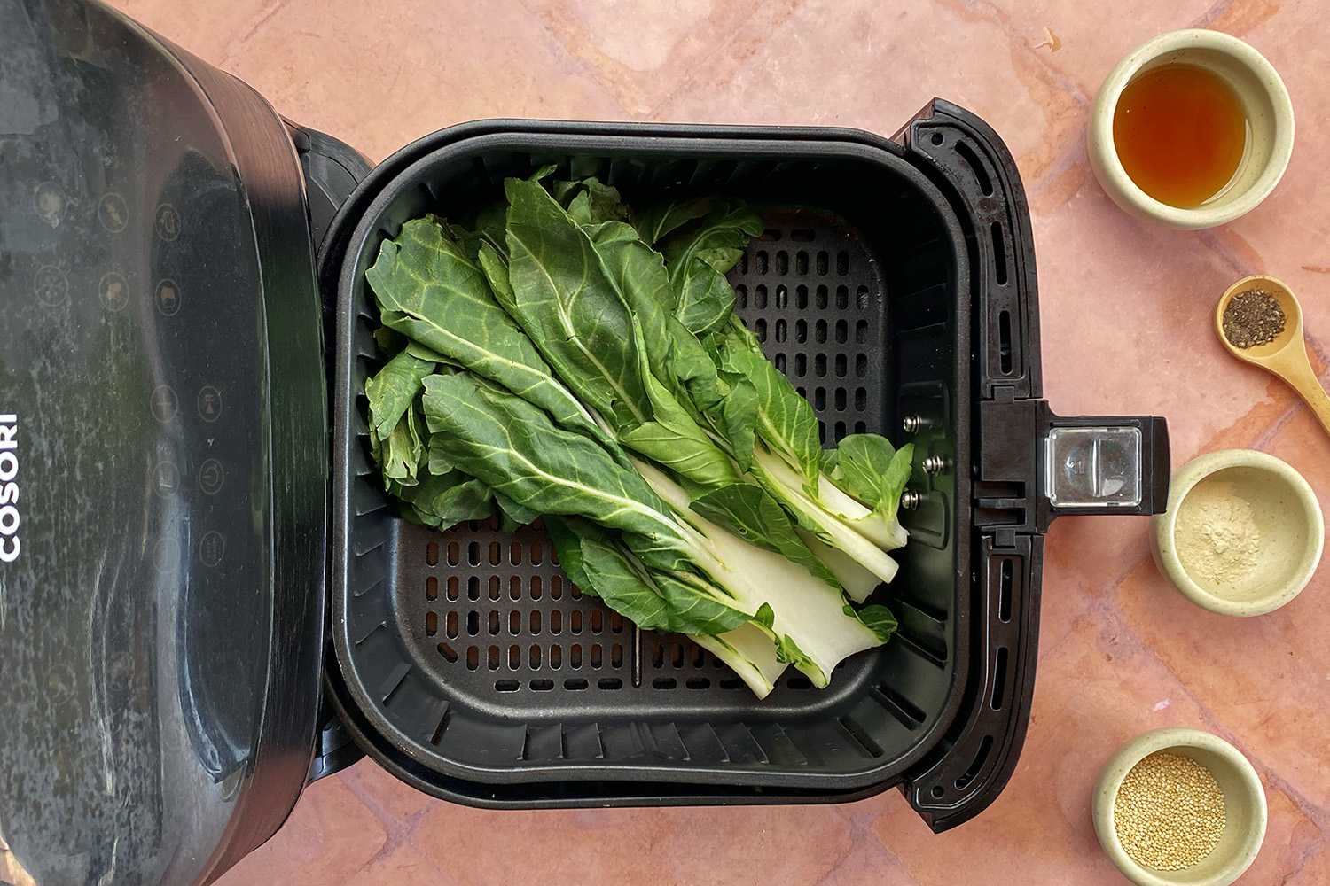Raw bok choy leaves being prepared to air fry.