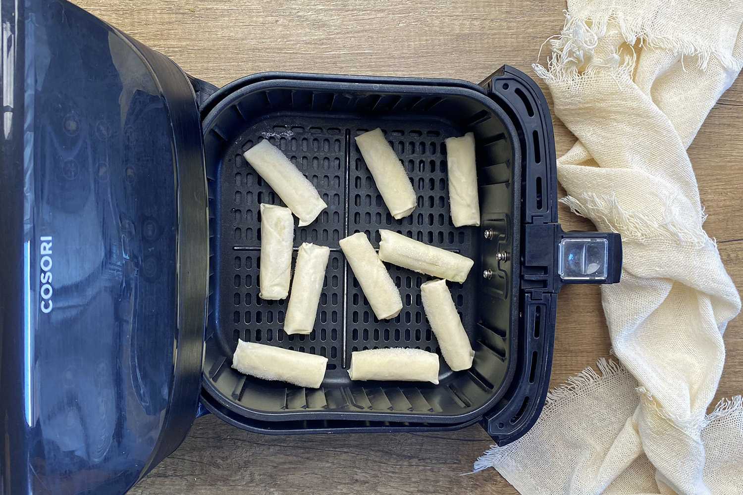 A single layer of frozen lumpia in air fryer basket.