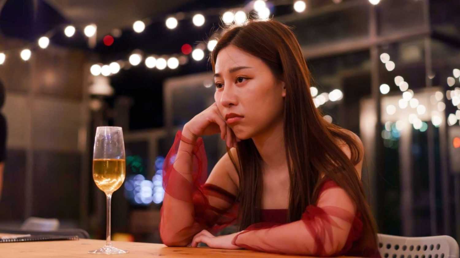 Young Asian woman feeling sad and heartbroken after breaking up with her boyfriend while sitting at restaurant