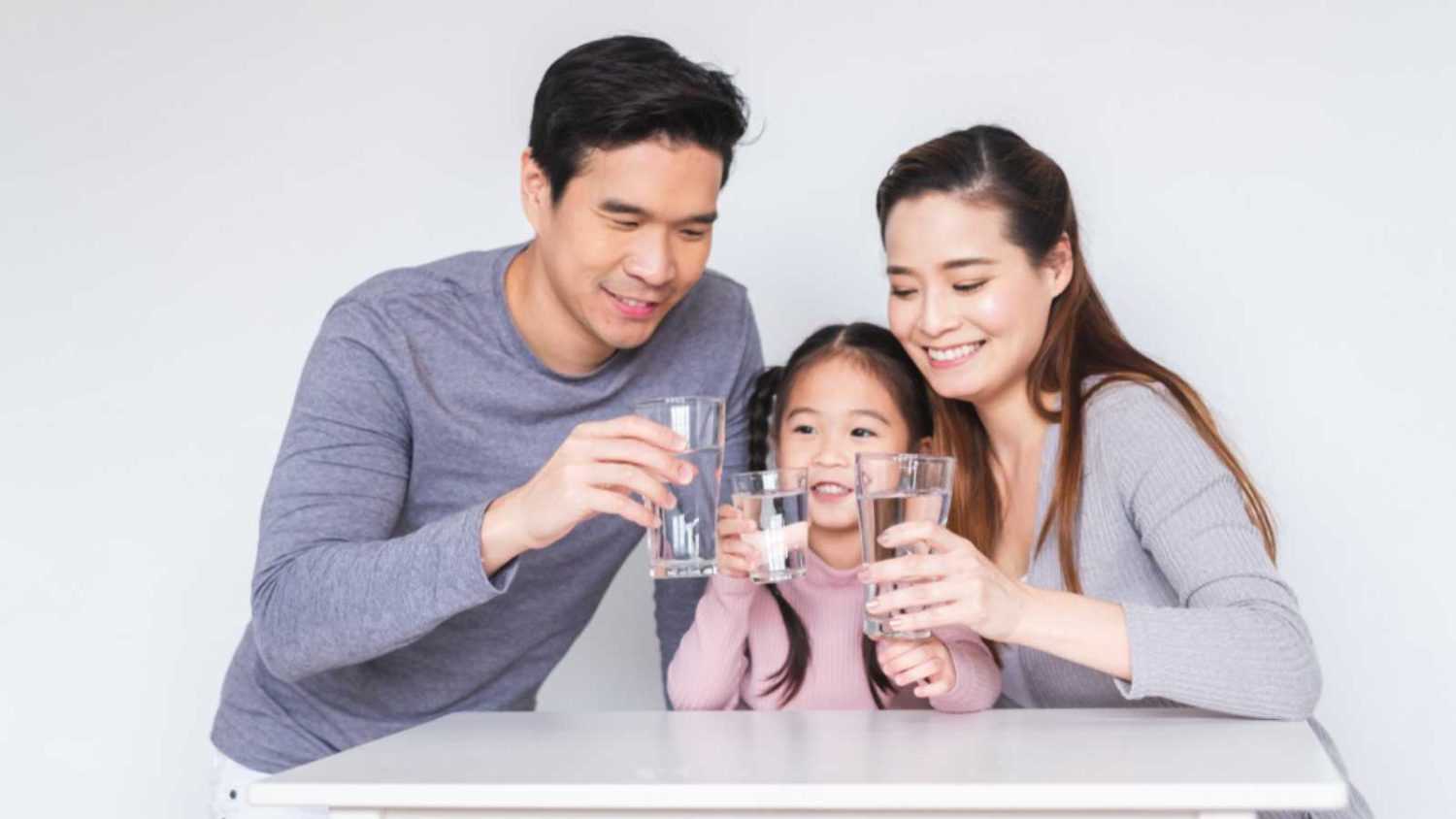Happy Asian family drinking fresh water for heathly concept