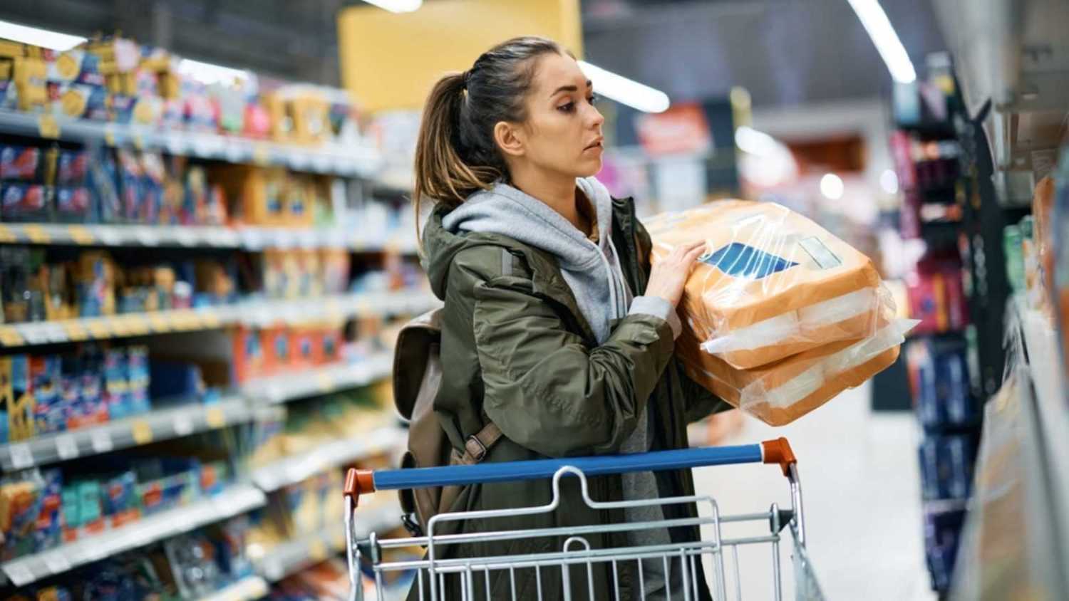 Young woman in panic buying for toilet paper at supermarket.