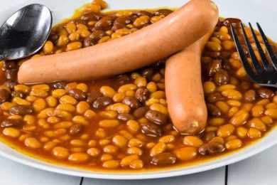 hot dogs served with baked beans on a plate