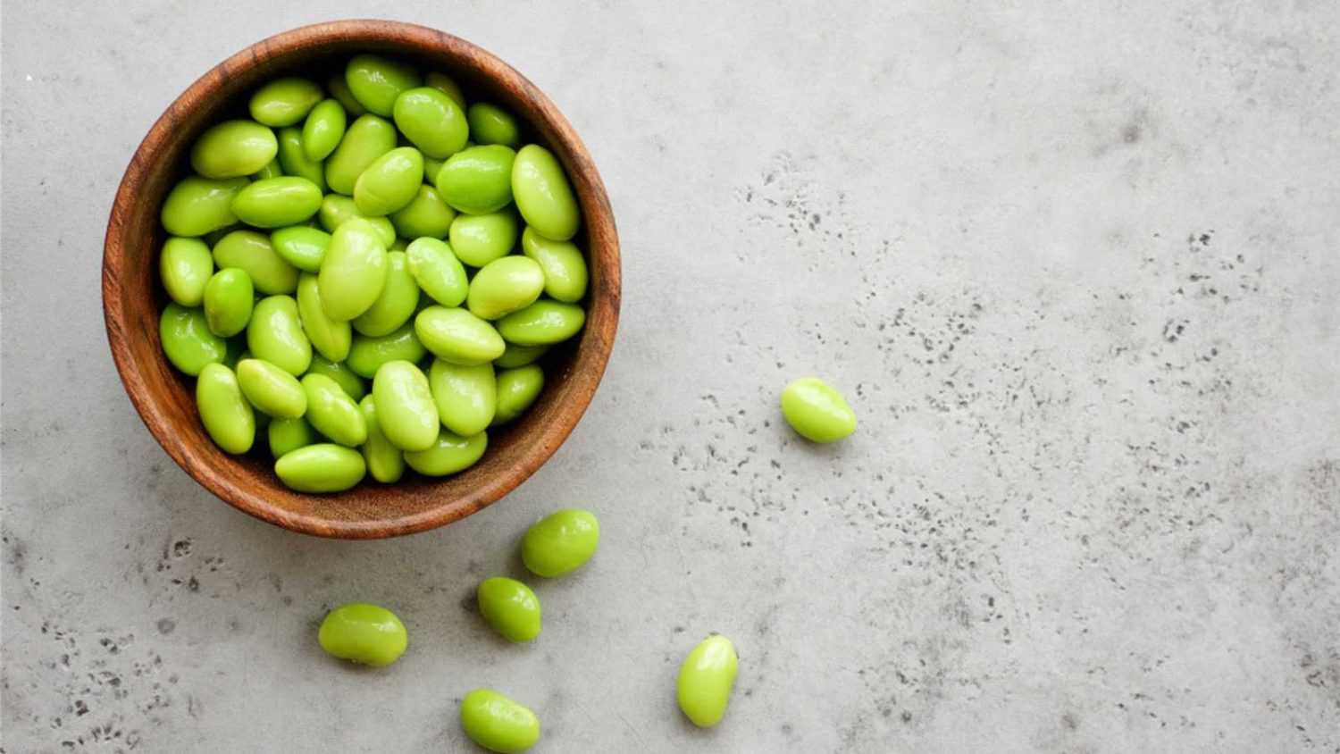 Edamame beans in bowl on light background. Close up view
