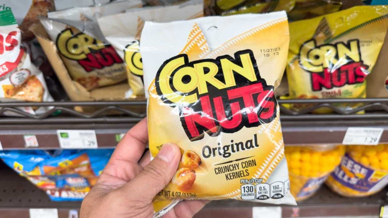 Los Angeles, California, United States - 05-05-2023: A view of a hand holding a package of Corn Nuts Original, on display at a local grocery store.