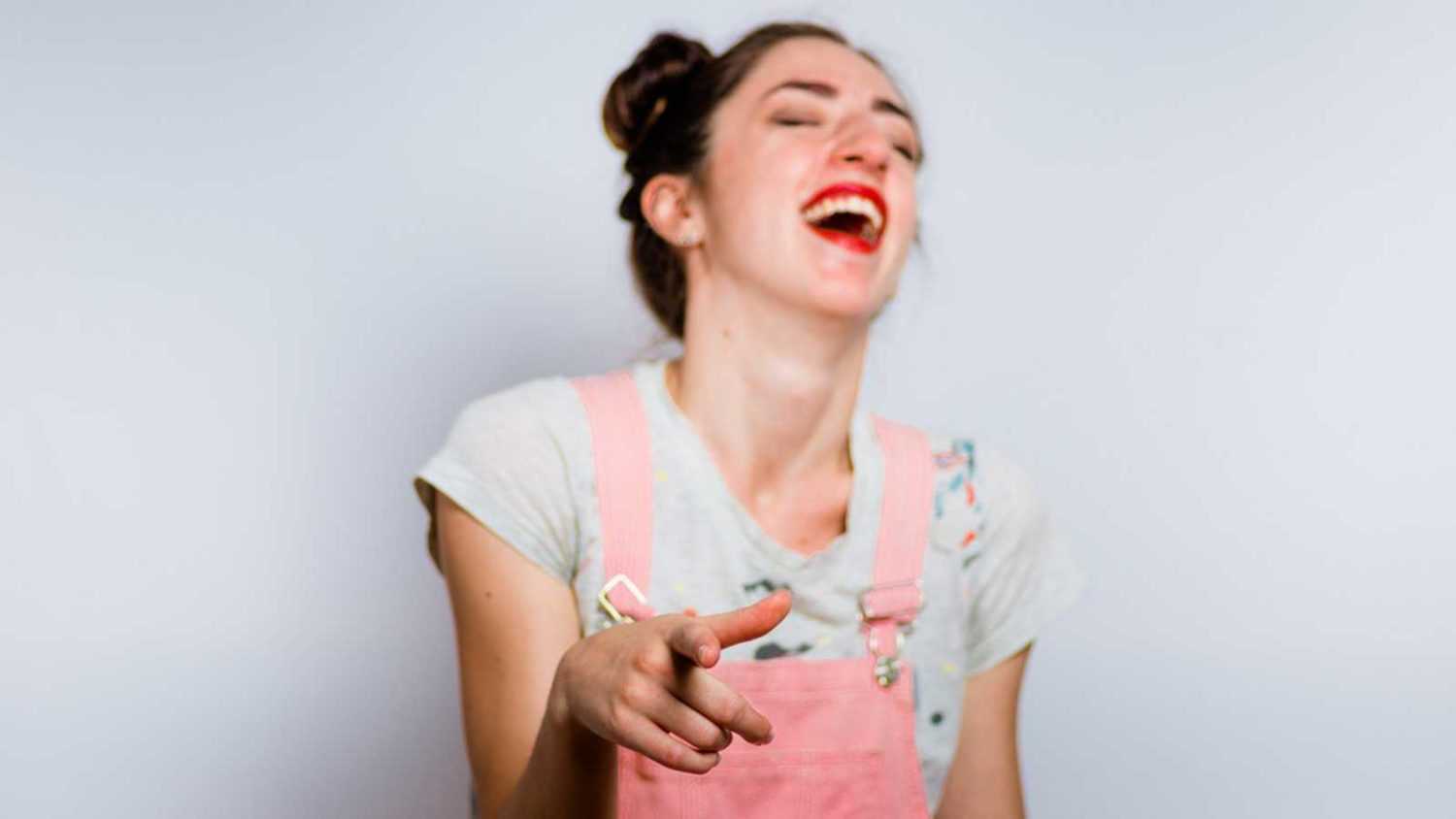 woman laughing with pointing hands