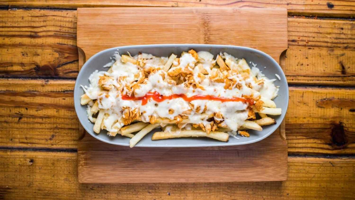 Poutin fries loaded with mayo dip isolated on wooden board top view on table fastfood
