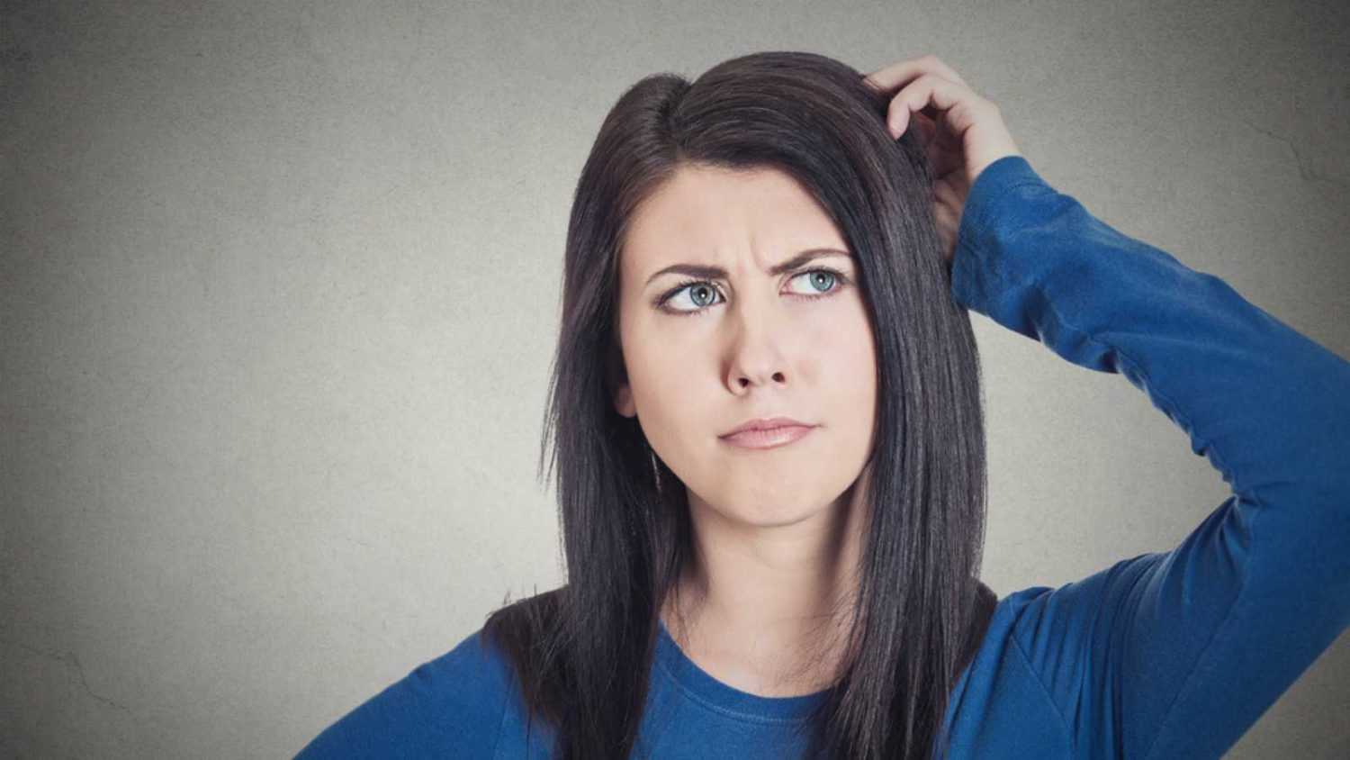 Woman scratching head confused